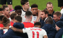 Gareth Southgate, head coach of England, talking to his players during a football game. 