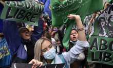 People celebrate Colombia's decision to decriminalize abortion, waving green flags and cheering.