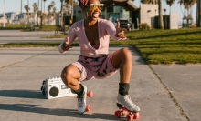 Black woman posing on roller skates with boombox behind them.