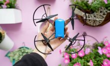 drone held in hand above pink background