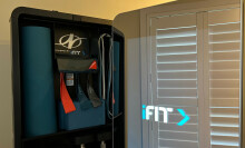 the NordicTrack Vault with its door open, displaying a yoga mat, yoga block, and resistance bands.