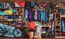 Outdoor clothing, bikes, coolers, and more outdoor gear hanging on wall