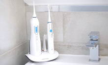 The electric toothbrush and water flosser set from Toiletree standing in someone's bathroom.