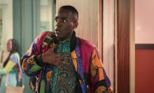 A teen clutches their chest in fear wearing in a bright patterned outfit.