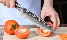 Person cutting up tomatoes with a Konig knife in a kitchen setting.
