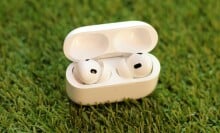 The Apple AirPods Pro resting in their case while propped up on the grass