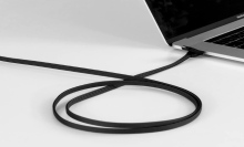 A black, multifunctional charging cable from RollingSquare plugged into a MacBook