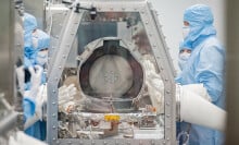 Scientists opening the OSIRIS-REx asteroid sample return lid at the NASA Johnson Space Center 