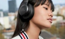 woman wears a pair of over-ear JBL headphones