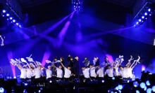 BTS perform onstage with a crew of backup dancers.