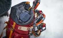 bose soundlink micro bluetooth speaker sits on top of a backpack placed in the snow