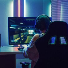 woman on computer playing video games with colorful LED lighting