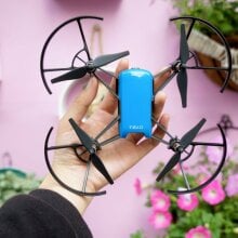 drone held in hand above pink background