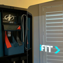 the NordicTrack Vault with its door open, displaying a yoga mat, yoga block, and resistance bands.