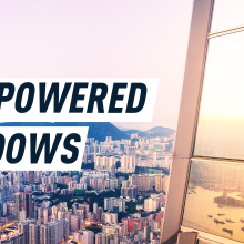 Sunlight reflects on the windows of a tall skyscraper, while a cityscape and a mountain appear in the background. Caption reads: "Sun-powered windows"