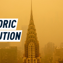 Aerial shot of the Empire State Building vailed in a cloud of yellow-ish smoke. Caption reads: historic pollution