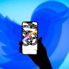 A shrinking Twitter logo behind a smartphone featuring the Threads app.