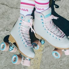impala retro roller skates on pavement with tube socks that read 'impala skate'