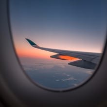 Wing of plane and sunset out window of airplane