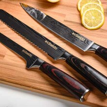 Three Seido knives shown on a cutting board surrounded by lemons and herbs.