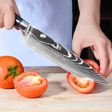Person cutting up tomatoes with a Konig knife in a kitchen setting.
