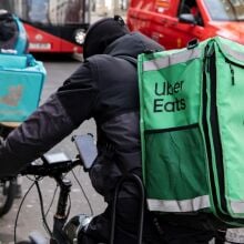 A delivery driver on a cycle with an "Uber Eats" package.