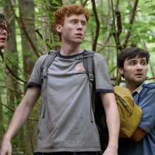 Three men hiking in a forest.