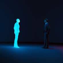 A man facing a hologram version of himself in dark moody lighting