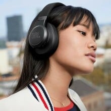 woman wears a pair of over-ear JBL headphones