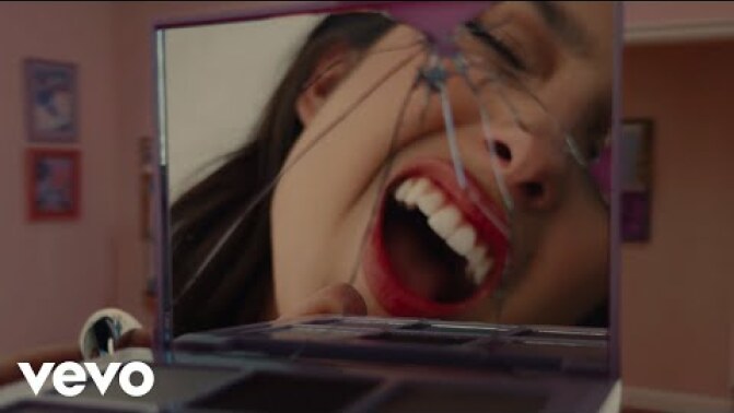 Olivia Rodrigo sings into a broken mirror.