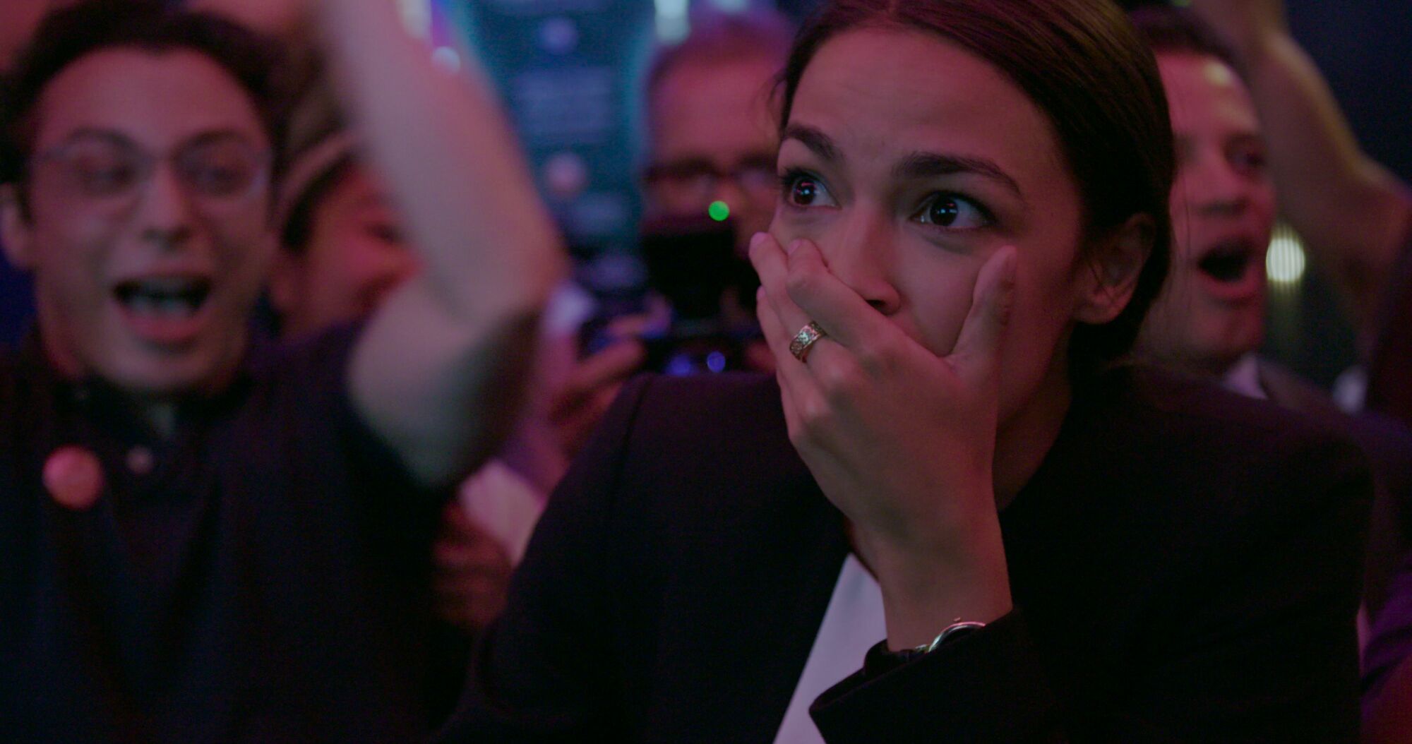 Alexandria Ocasio-Cortez looks shocked while celebrating.