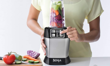 A person pushes a button on a blender