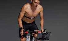 A man uses an exercise bike with a Garmin heart rate monitor.