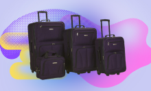 4-piece luggage set in deep purple against a purple, pink, blue, and yellow background