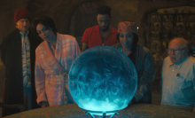 The cast of 'Haunted Mansion' standing around a magic crystal ball