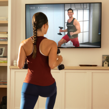 woman standing in front of a TV playing a workout video