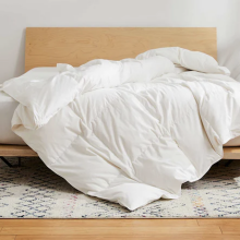 White duvet cover on a bed with a wooden bed frame