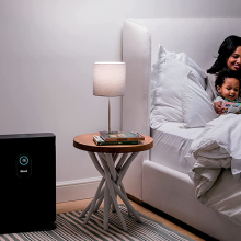 mom reading to son in bedroom, shark air purifier to the left
