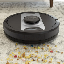robot vacuum picking up cereal on a rug