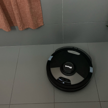 Shark robot vacuum cleaning tile floor near bathtub