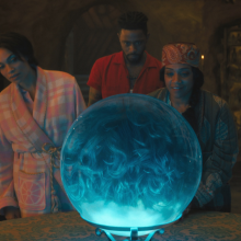 The cast of 'Haunted Mansion' standing around a magic crystal ball
