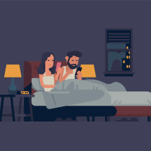 Couple checking their phones in bed at night