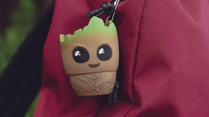 The Bitty Boomers Mini Bluetooth Speaker shaped like Groot from Guardians of the Galaxy, hanging off a backpack